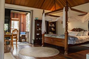 1 dormitorio con cama con dosel y comedor en Barrabup Sanctuary BirdHide, en Nannup