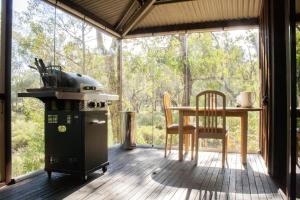a screened in porch with a stove and a table at Barrabup Sanctuary BirdHide in Nannup