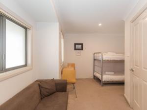 a living room with a couch and a bed at Pentagon 2 65 Gippsland Street in Jindabyne