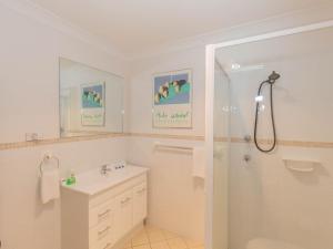 a white bathroom with a shower and a sink at Pentagon 2 65 Gippsland Street in Jindabyne