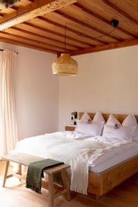 a bedroom with a large white bed with a wooden ceiling at Winzer Appartements Kogler in Leutschach