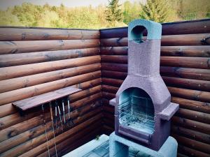 a stone oven sitting next to a wooden wall at TRENDY HOUSE 193 in Mátranovák