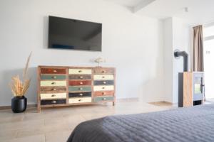 a bedroom with a dresser with a tv on the wall at Meerhotel Großenbrode in Großenbrode