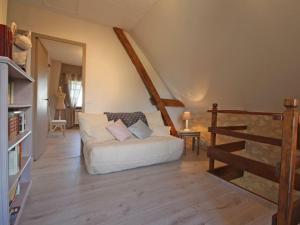 ein Wohnzimmer mit einer weißen Couch und einer Treppe in der Unterkunft Gîte Bellou-sur-Huisne, 5 pièces, 7 personnes - FR-1-497-29 in Bellou-sur-Huisne