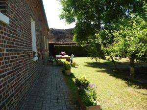a patio with a table and a bench in a yard at Charmant appartement à la ferme, 2 chambres, Wi-Fi, proche Auxi-le-Château - FR-1-376-28 in Wavans