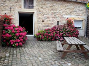 a wooden bench in front of a building with pink flowers at Gîte cosy 3 chambres à 3 km de la mer avec jardin, terrasse, WIFI et animaux acceptés - FR-1-376-24 in Beuvrequen +9 photos