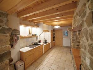 uma cozinha com armários de madeira e uma parede de pedra em Gîte Montarcher, 4 pièces, 6 personnes - FR-1-496-11 em Montarcher
