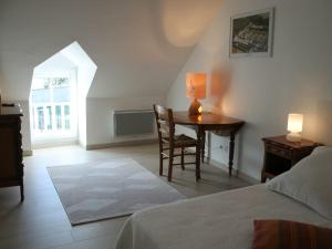 a bedroom with a table with a lamp and a bed at Gîte Savigny-en-Véron, 3 pièces, 4 personnes - FR-1-381-209 in Savigny-en-véron