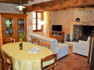 ein Wohnzimmer mit einem Tisch und einem Kamin in der Unterkunft Gîte Paulmy, 4 pièces, 7 personnes - FR-1-381-321 in Paulmy