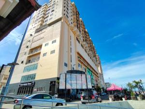 a tall building with cars parked in front of it at Ridel Sunset Hotel in Kota Bharu
