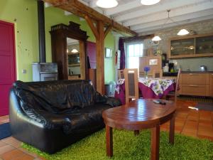 uma sala de estar com um sofá de couro e uma mesa em Gîte Civray-sur-Esves, 4 pièces, 6 personnes - FR-1-381-323 em Civray-sur-Esves