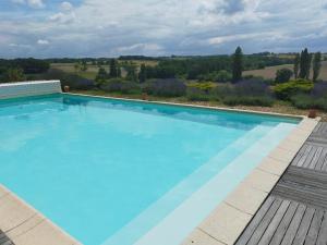 a large blue swimming pool with a view at Maison de campagne avec piscine, proche de Périgueux – 2 chambres, BBQ, activités variées à proximité - FR-1-616-54 in Mensignac