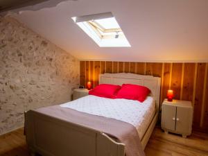 a bedroom with a bed with two red pillows at Maison de campagne avec piscine, proche de Périgueux – 2 chambres, BBQ, activités variées à proximité - FR-1-616-54 in Mensignac +19 photos