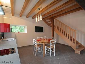 eine Küche und ein Esszimmer mit einem Tisch und Stühlen in der Unterkunft Gîte Marchainville, 2 pièces, 2 personnes - FR-1-497-84 in Marchainville