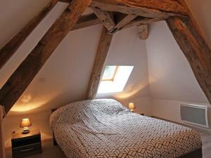ein Schlafzimmer mit einem Bett im Dachgeschoss in der Unterkunft Gîte Marchainville, 2 pièces, 2 personnes - FR-1-497-84 in Marchainville