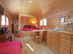 a kitchen and dining area of a wooden cabin at Gîte Radon, 2 pièces, 3 personnes - FR-1-497-130 in Radon