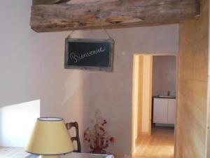 ein Zimmer mit einem Tisch mit einer Lampe und einem Schild an der Wand in der Unterkunft Gîte Saint-Georges-de-Baroille, 4 pièces, 6 personnes - FR-1-496-170 in Saint-Georges-de-Baroille