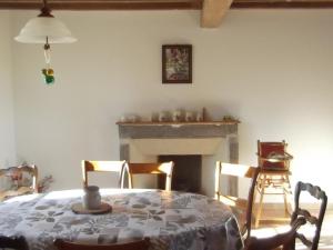 une salle à manger avec une table et une cheminée dans l'établissement Gîte Saint-Georges-de-Baroille, 4 pièces, 6 personnes - FR-1-496-170, à Saint-Georges-de-Baroille