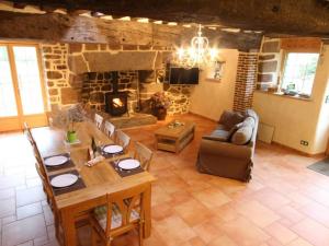 ein Wohnzimmer mit einem Tisch und einem Kamin in der Unterkunft Gîte La Baroche-sous-Lucé, 3 pièces, 5 personnes - FR-1-497-7 in La Baroche-sous-Lucé