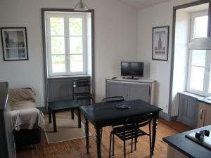 een woonkamer met een tafel en een televisie bij Gîte Saint-André-d'Apchon, 2 pièces, 2 personnes - FR-1-496-142 in Saint-André-dʼApchon