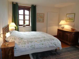 - une chambre avec un lit et une fenêtre avec des rideaux verts dans l'établissement Gîte Essertines-en-Donzy, 5 pièces, 10 personnes - FR-1-496-200, à Essertines-en-Donzy