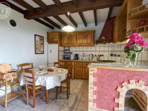 een keuken met een tafel en een keuken met een open haard bij Gîte Saint-Christo-en-Jarez, 5 pièces, 8 personnes - FR-1-496-204 in Saint-Christo-en-Jarez