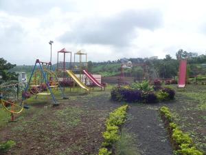een speeltuin met een glijbaan in een park bij SS Resort Near Jaysagar Lake in Jawhār