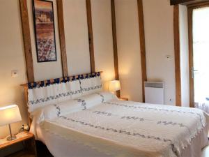 1 dormitorio con 1 cama blanca grande y 2 lámparas en Gîte Mazeyrolles, 3 pièces, 4 personnes - FR-1-616-106, en Mazeyrolles