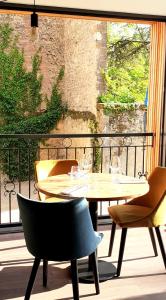 une table et des chaises assises sur un balcon dans l'établissement Hotel-Restaurant des Augustins - Cosy Places by CC - Proche Sarlat, à Saint-Cyprien