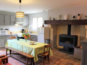 Il comprend une cuisine avec une table et une cheminée. dans l'établissement Gîte Mensignac, 3 pièces, 5 personnes - FR-1-616-40, à Mensignac