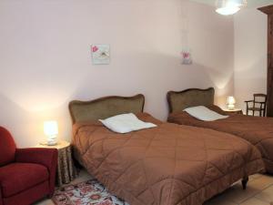 um quarto com 2 camas, uma cadeira e um sofá em Gîte Mensignac, 3 pièces, 5 personnes - FR-1-616-40 em Mensignac