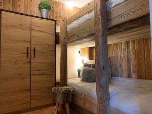 a bedroom with a bunk bed with a wooden wall at Chalet Apart Hansler in Ehrwald