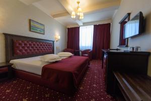 a hotel room with a bed and a television at Hotel Golden Palace in Mamaia