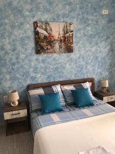 una camera da letto con un letto con pareti blu e due tavoli di Apartments Blago Sutomore a Sutomore