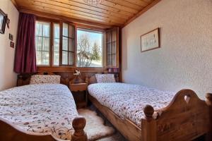 1 Schlafzimmer mit 2 Betten und einem Fenster in der Unterkunft Chalet Soldanella 10 guests Gstaad in Gstaad
