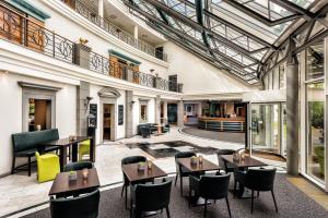 een overdekte patio met tafels en stoelen in een gebouw bij Seminaris Hotel Leipzig in Leipzig