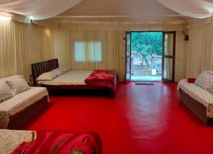 una camera con tre letti e un tappeto rosso di Green Environment Stay a Kalyan