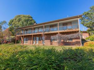 a large brick building on a hill with trees at Winterwood 9 Camira Ave in Jindabyne