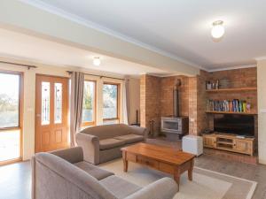 a living room with a couch and a coffee table at Winterwood 9 Camira Ave in Jindabyne