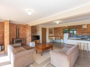 a living room with two chairs and a table at Winterwood 9 Camira Ave in Jindabyne