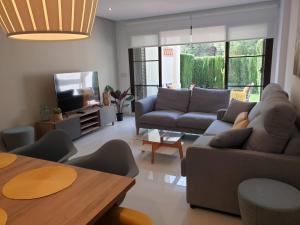 uma sala de estar com um sofá e uma televisão em Adosado Los Olivos, Sierra Cortina em Finestrat