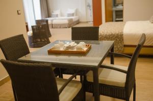 a dining room table with chairs and a bed at Hôtel MENABE'L in Antsirabe