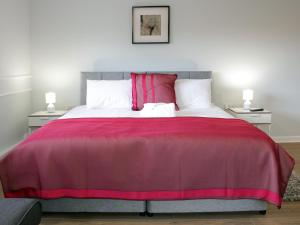 um quarto com uma cama grande e uma colcha rosa em Hugh O'Neill Ambassador Suite em Dungannon