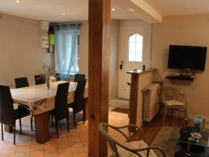 comedor con mesa, sillas y TV en Gîte Daglan, 3 pièces, 4 personnes - FR-1-616-93, en Daglan