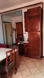 cocina con armarios de madera y mesa con ordenador en Appartamento Giulia, en Nizza Monferrato