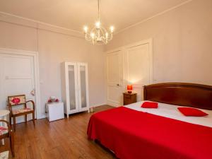 een slaapkamer met een rood bed en een kroonluchter bij Gîte Villefranche-du-Périgord, 4 pièces, 6 personnes - FR-1-616-65 in Villefranche-du-Périgord
