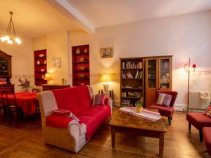 een woonkamer met een rode bank en een tafel bij Gîte Villefranche-du-Périgord, 4 pièces, 6 personnes - FR-1-616-65 in Villefranche-du-Périgord