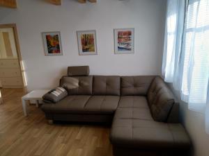 a living room with a brown leather couch at APARTMÁNY NA VÝSLUNÍ in Horní Maxov