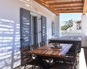 a wooden table and chairs on the balcony of a house at Villa Nelleas in Adamas