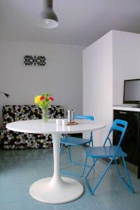 una mesa blanca con 2 sillas y una mesa con flores en Marechiaro Casa, en Nápoles